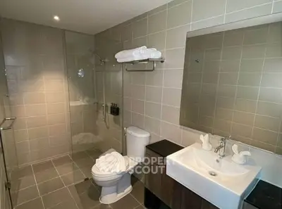 Modern bathroom with sleek design, featuring a glass shower, stylish sink, and elegant tile work.