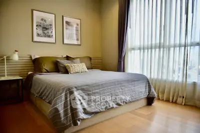 Cozy bedroom with large window and stylish decor in modern apartment.