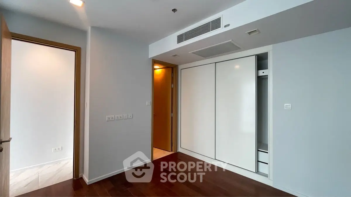 Modern bedroom with sleek built-in wardrobe and wooden flooring