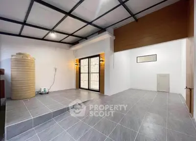 Spacious modern interior with tiled flooring and large windows, perfect for versatile living space.