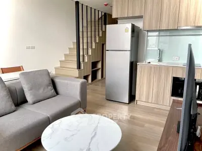 Modern open-plan living room with kitchen and stylish staircase