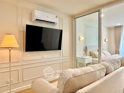 Modern living room with cozy sofa, wall-mounted TV, and air conditioning unit.