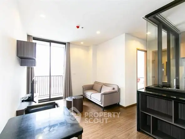 Modern living room with sleek furniture and balcony access in a stylish apartment.
