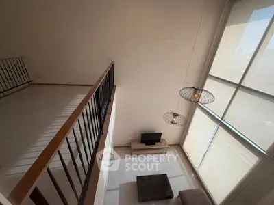 Modern loft-style living room with high ceilings and large windows