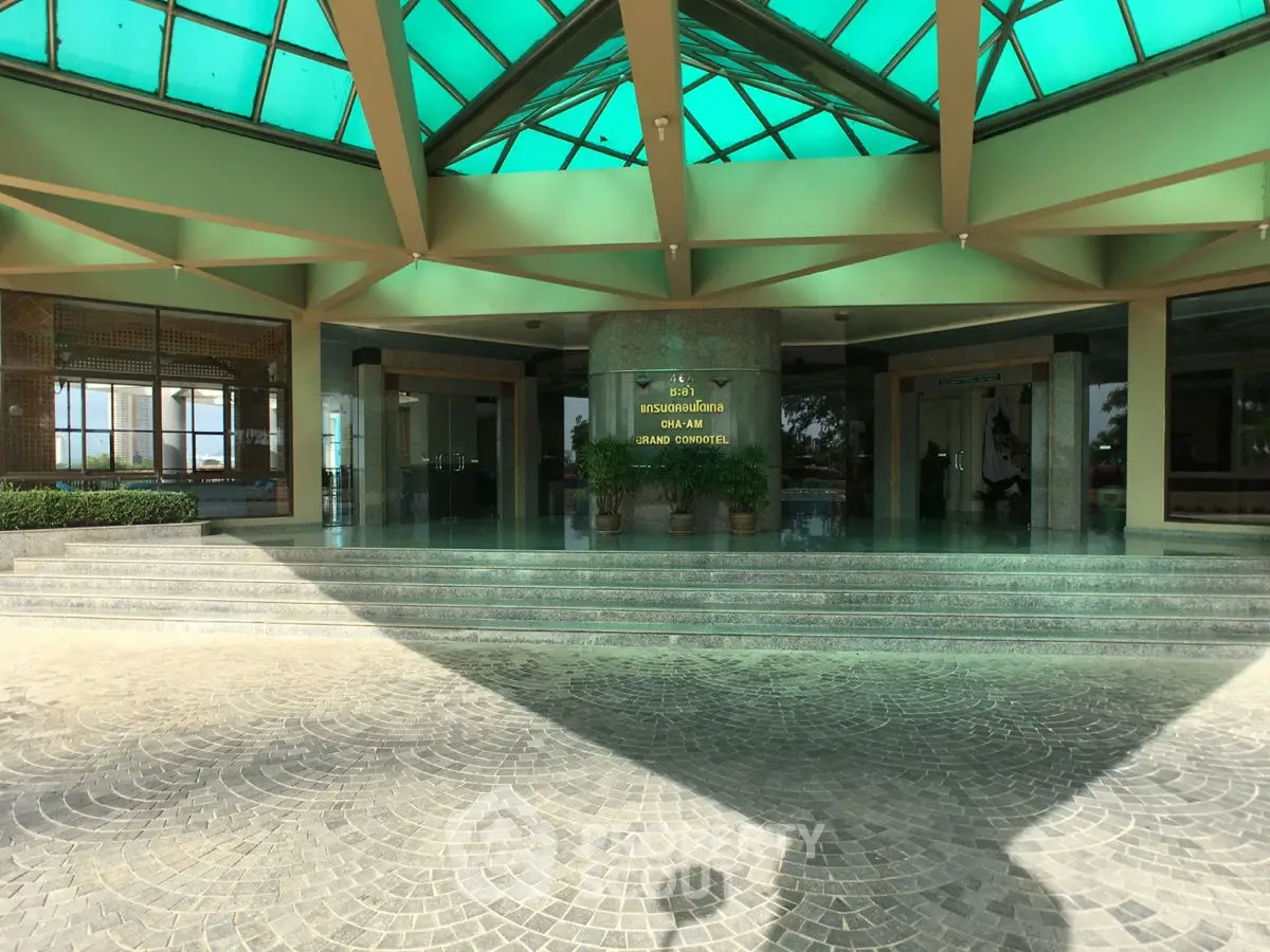 Grand entrance with modern architecture and glass ceiling, showcasing luxury and elegance.