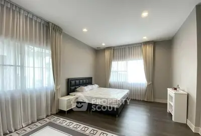 Spacious bedroom with elegant decor and large windows for natural light