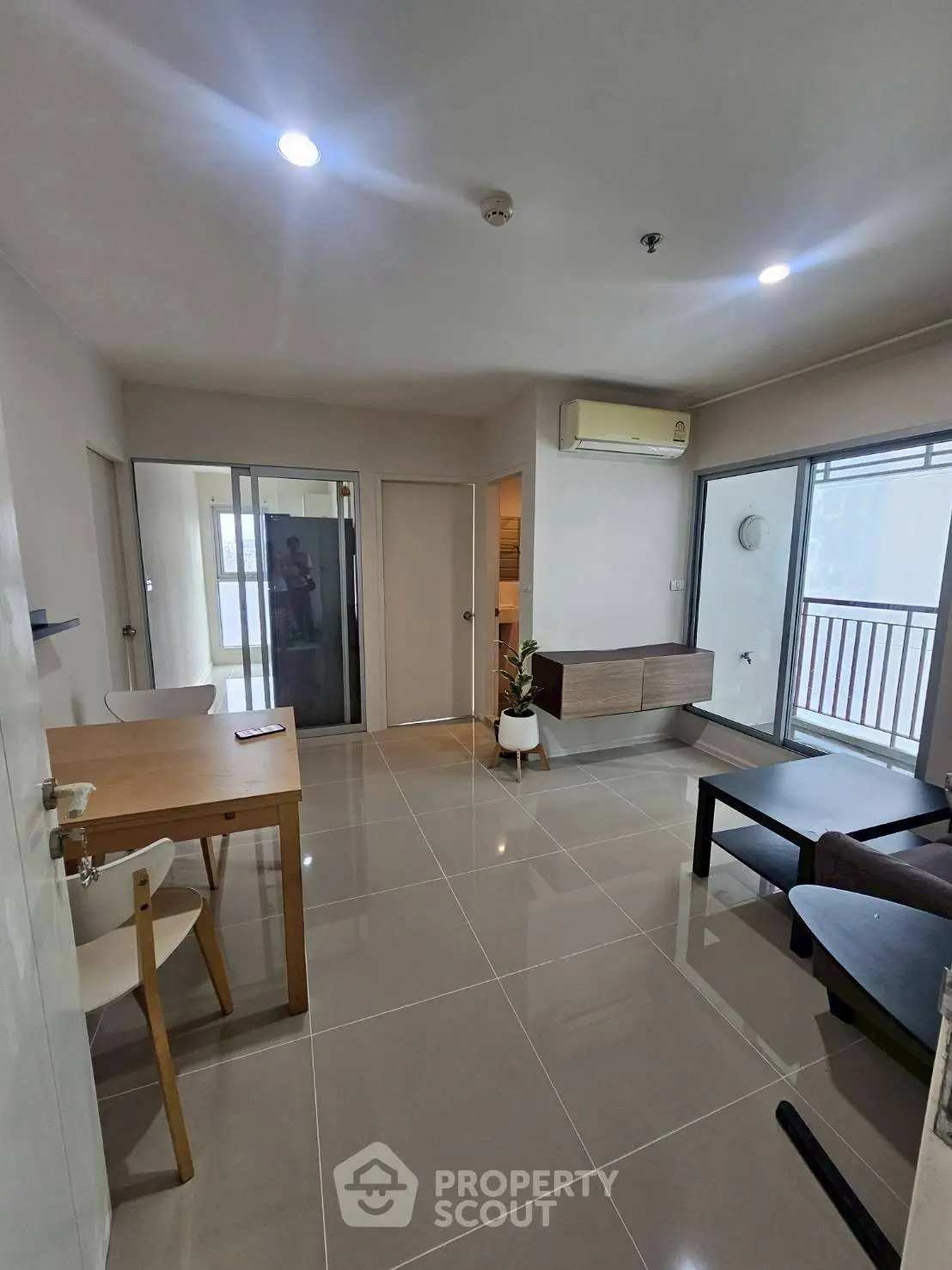 Modern living room with sleek furniture and balcony access in a stylish apartment.