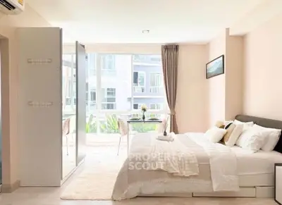 Bright and airy bedroom with large windows and modern decor in a stylish apartment.