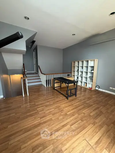 Spacious modern living room with wooden flooring and stylish staircase