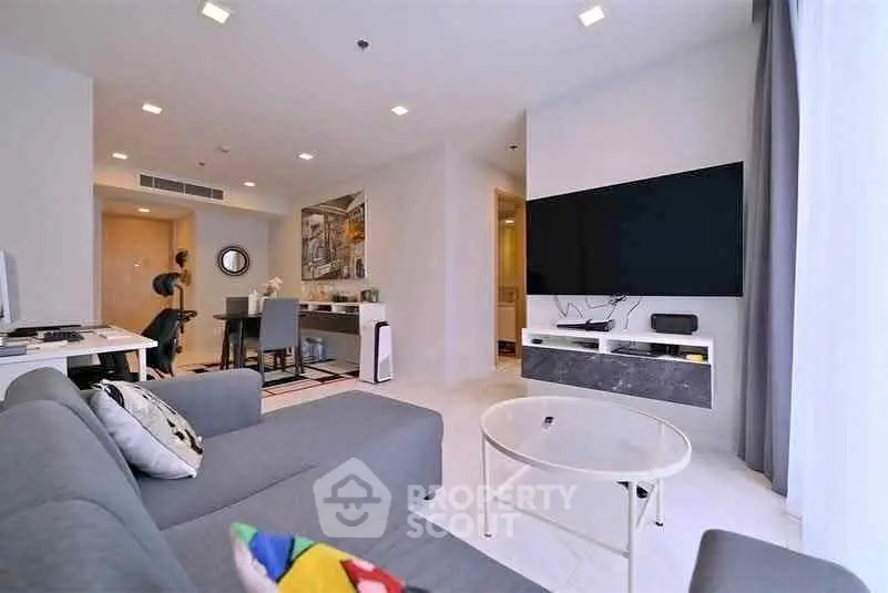 Modern living room with sleek furniture and large TV, perfect for relaxation and entertainment.