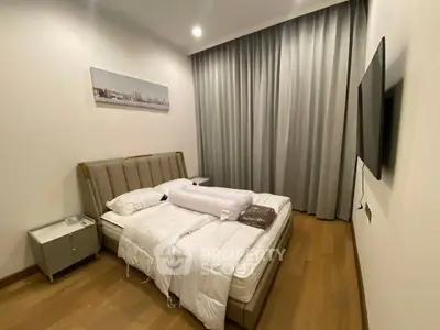 Modern bedroom with stylish decor, featuring a comfortable bed, sleek nightstand, and wall-mounted TV.