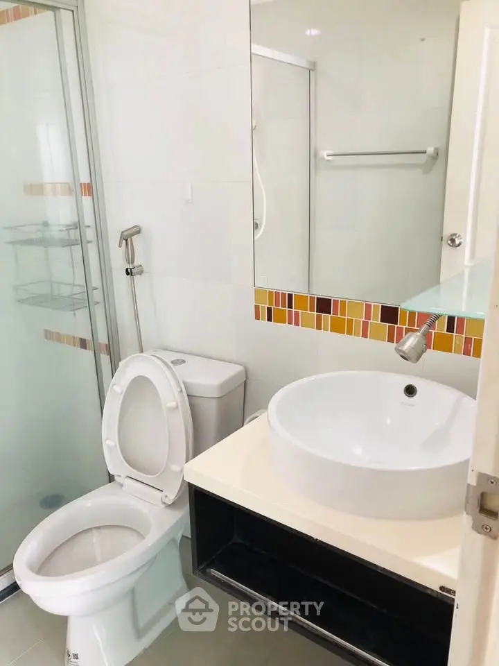Modern bathroom with glass shower and stylish sink in a contemporary apartment.