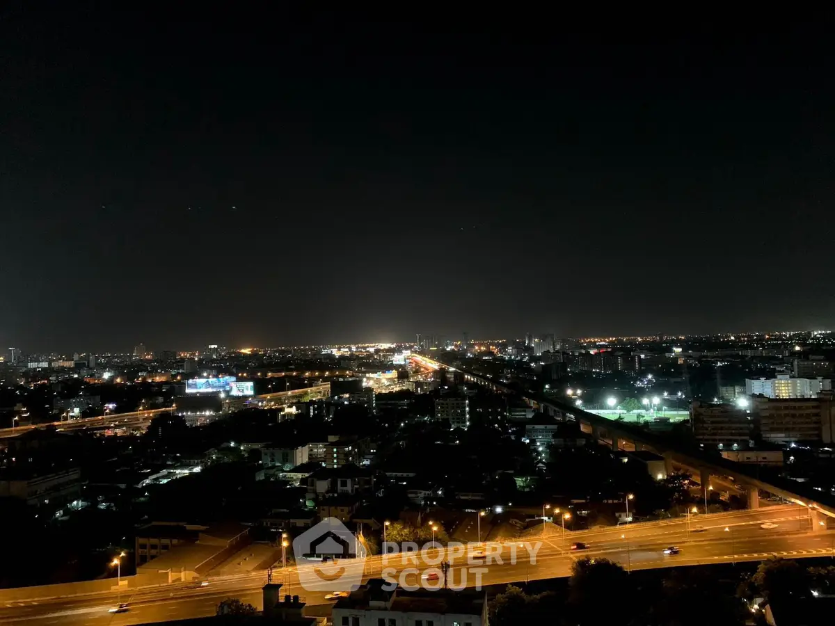Stunning cityscape night view from a high-rise building, showcasing vibrant lights and urban skyline.