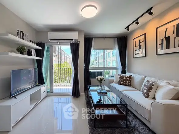 Modern living room with sleek decor and balcony view in urban apartment.