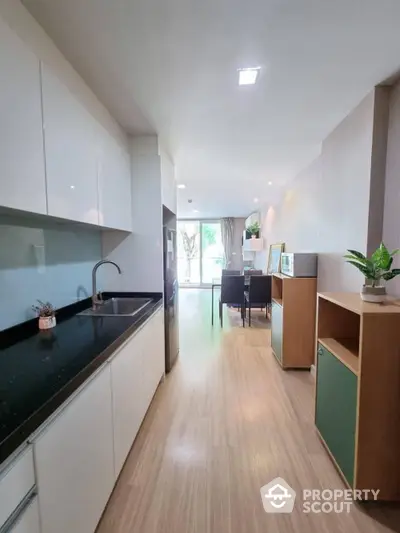 Spacious open-plan kitchen with modern appliances flows into a bright dining area, perfect for entertaining guests in style.