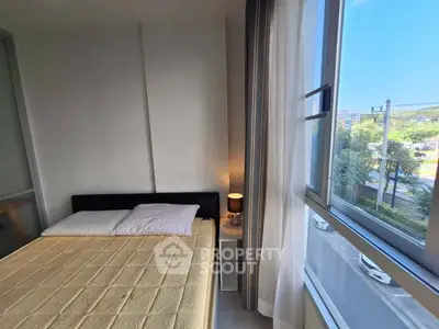 Bright bedroom with large window and cozy bed in modern apartment