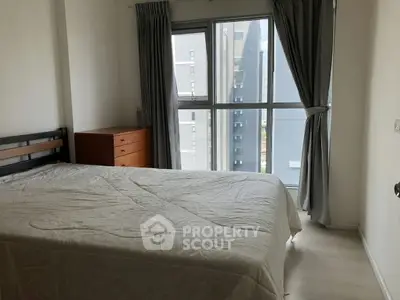 Bright bedroom with large window and modern furnishings in urban apartment