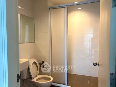 Modern bathroom with sleek design and sliding shower door in a real estate property.