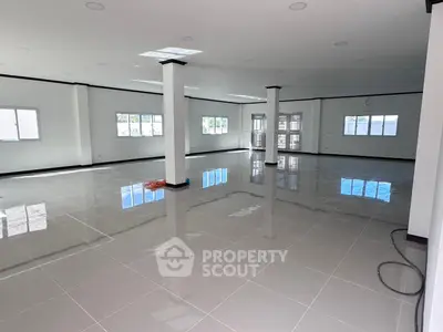 Spacious open-plan interior with glossy tiled floors and ample natural light, perfect for versatile use.