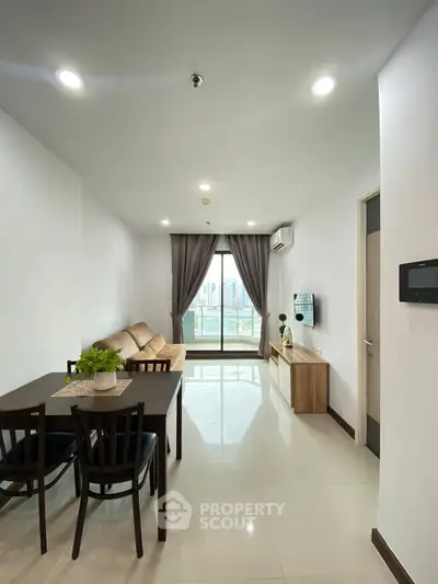 Modern living room with city view, featuring sleek furniture and abundant natural light.