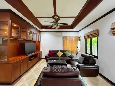 Spacious living room with elegant wooden accents and cozy leather seating