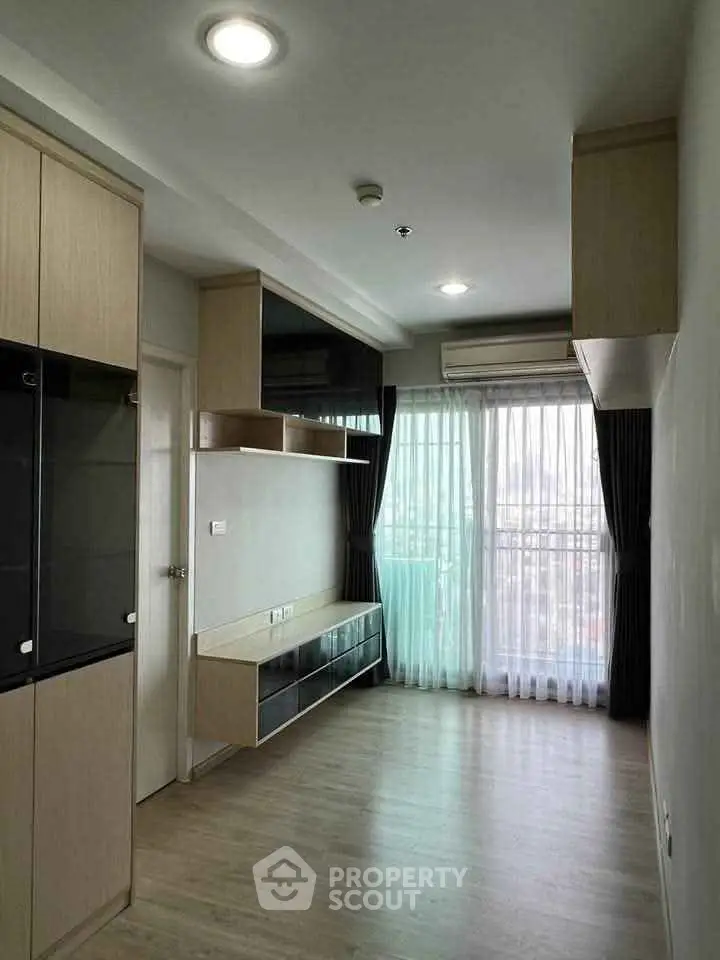 Modern living room with large windows and built-in storage in a stylish apartment.