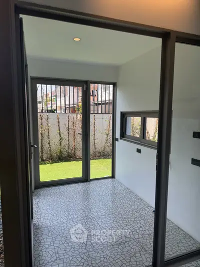 Modern enclosed patio with large windows and garden view, perfect for relaxation.