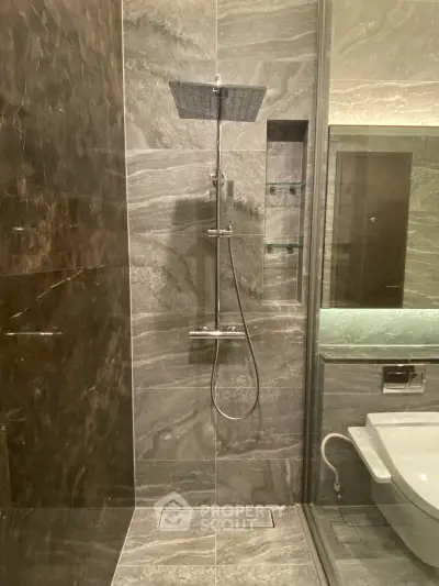 Luxurious modern bathroom with sleek marble tiles and high-end shower fixtures.