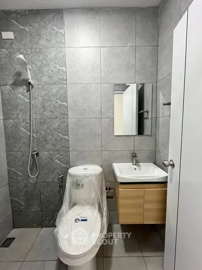 Modern bathroom with sleek fixtures and tiled walls in a contemporary apartment.