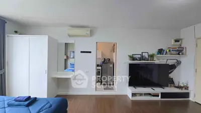 Modern living room with sleek TV setup and open kitchen view