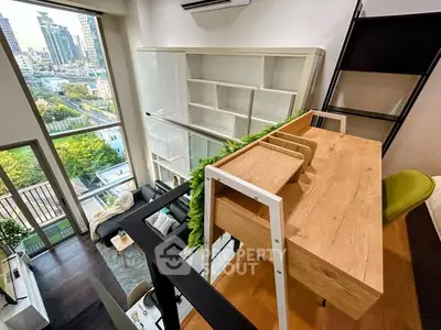 Modern loft apartment with high ceilings and large windows offering a stunning city view.