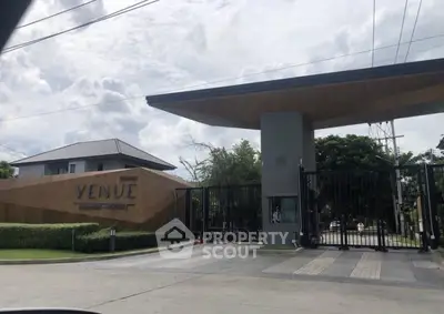 Secure gated community entrance with modern design, showcasing the exclusive Venue Residences with lush landscaping and a welcoming atmosphere, ideal for upscale living.