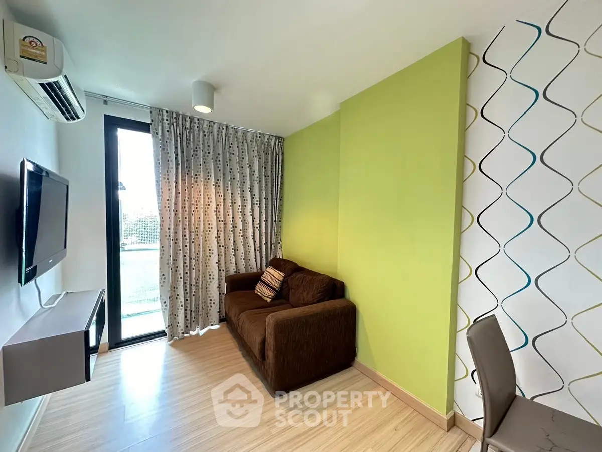 Modern living room with green accent wall and balcony view
