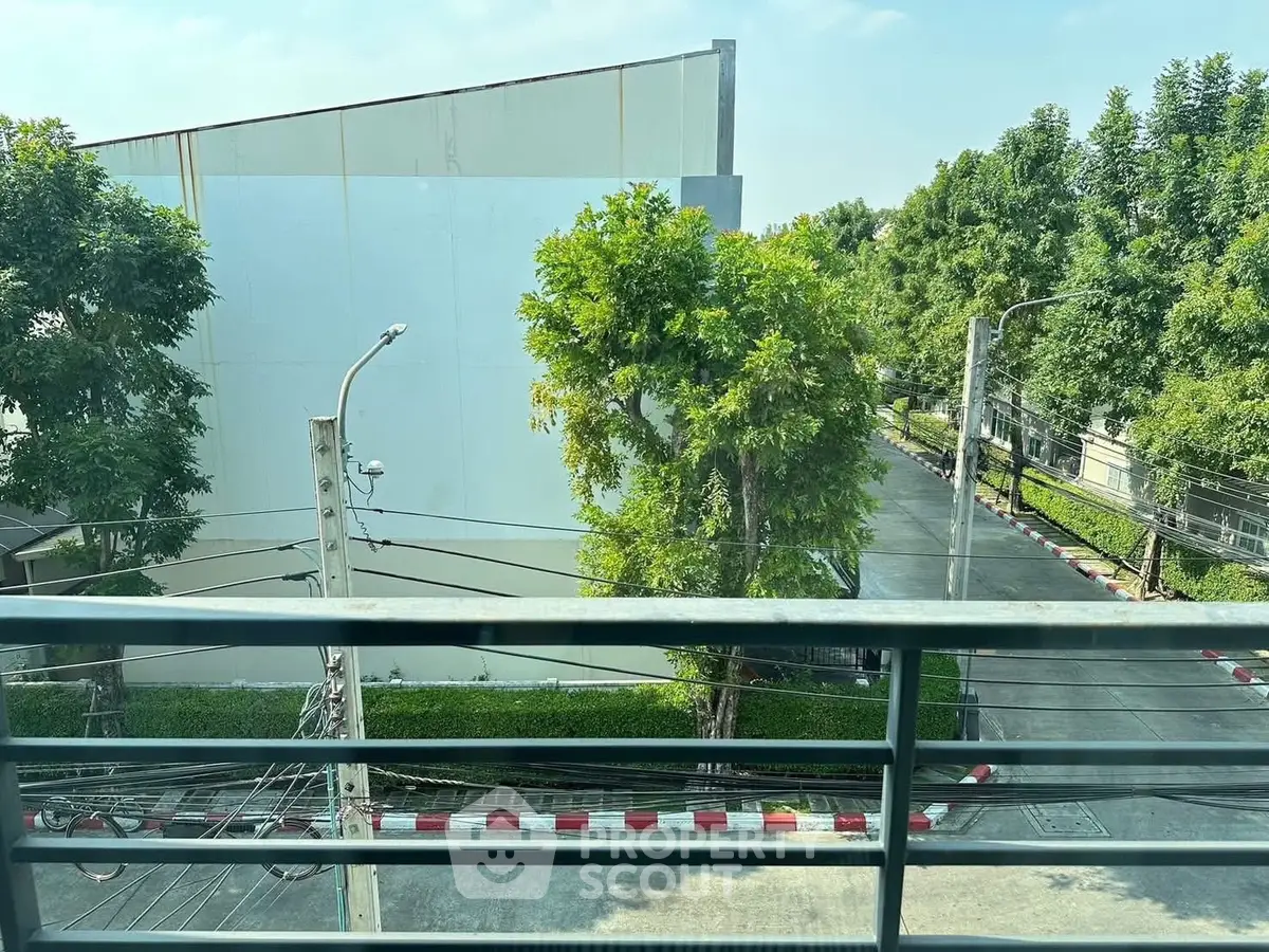 Scenic view from balcony overlooking lush greenery and quiet street