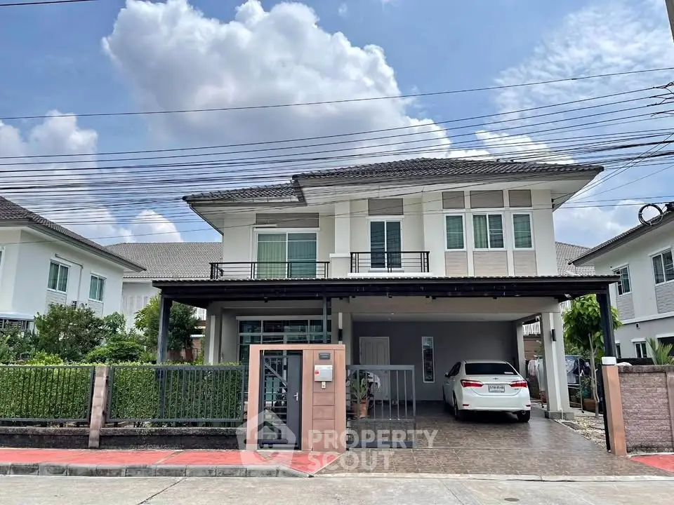 Charming two-story house with spacious driveway and lush greenery in a serene neighborhood.