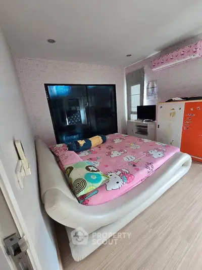 Cozy bedroom with unique decor and large window for natural light.