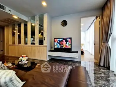 Luxurious living room with modern decor and large TV, featuring marble flooring and elegant curtains.