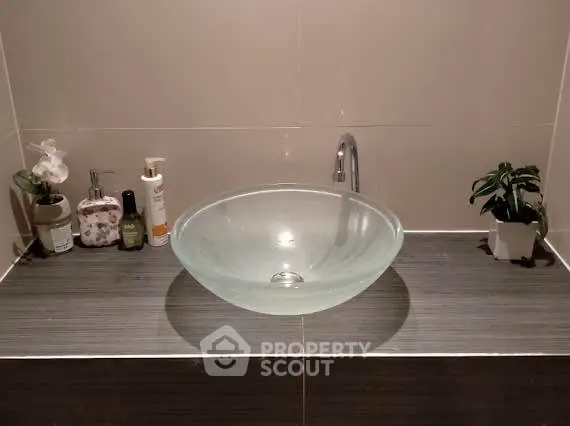 Modern bathroom sink with glass bowl and elegant decor