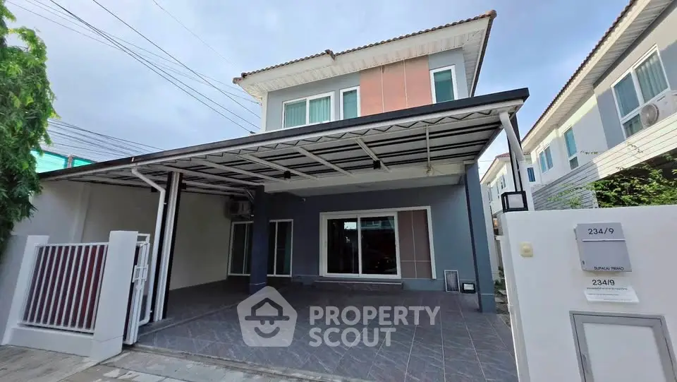 Modern two-story house with spacious carport and sleek exterior design.