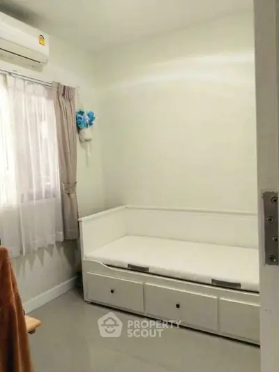 Cozy small bedroom with daybed and air conditioning, perfect for minimalist living.
