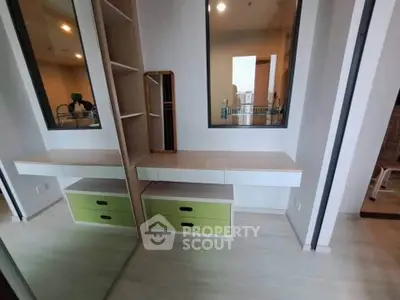 Modern bedroom with built-in storage and stylish mirror in a contemporary apartment.