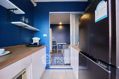 Modern kitchen with sleek appliances and open layout leading to cozy living area.