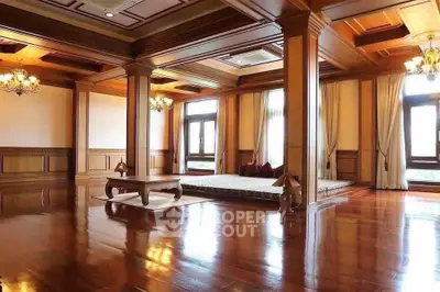 Luxurious wooden interior with elegant lighting and large windows in a spacious living area.