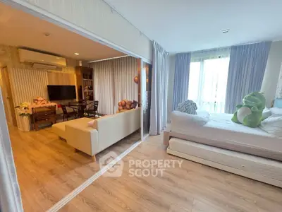 Modern open-plan living room and bedroom with stylish decor and natural light.
