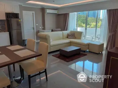 Spacious modern living room with elegant furniture and large windows offering a scenic view.