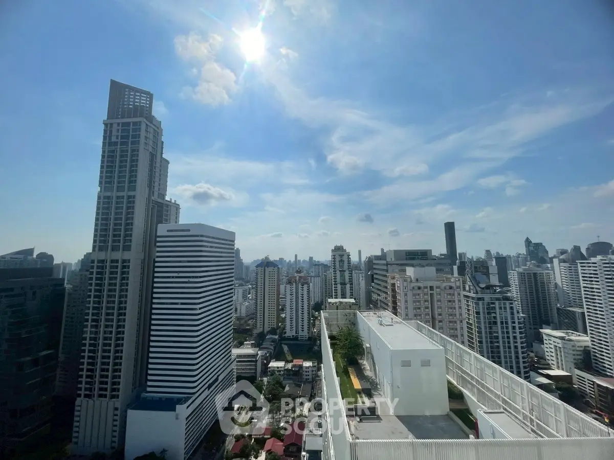 Stunning cityscape view from a high-rise building showcasing modern architecture and clear blue skies.