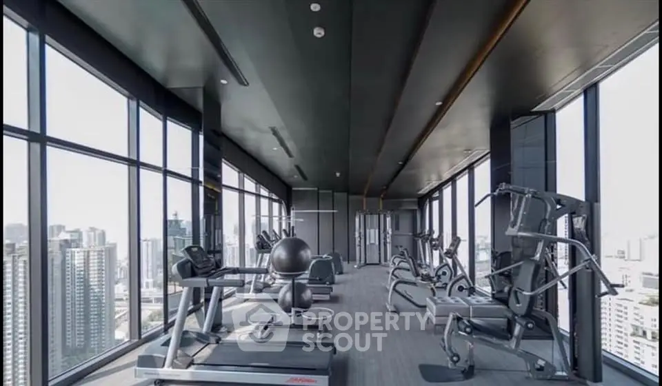 Luxurious high-rise gym with panoramic city views and modern fitness equipment.
