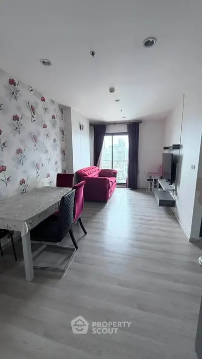 Spacious living room with floral wallpaper and modern furniture, featuring a large window with city view.