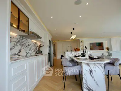 Luxurious open-layout kitchen and dining area with marble accents and modern design.