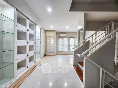 Spacious modern living room with elegant staircase and large windows